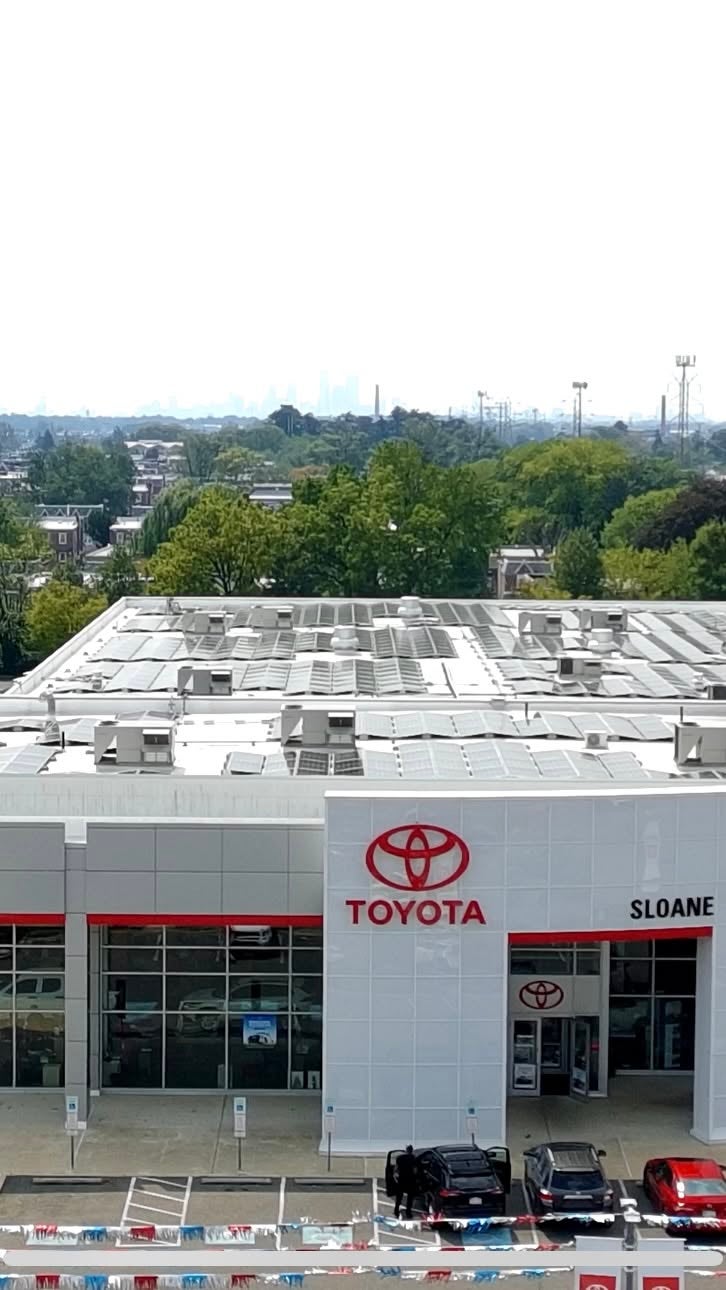 Aerial view of Sloane Toyota of Philadelphia on Cottman Avenue, with rowhouses and the Center City skyline in the distance